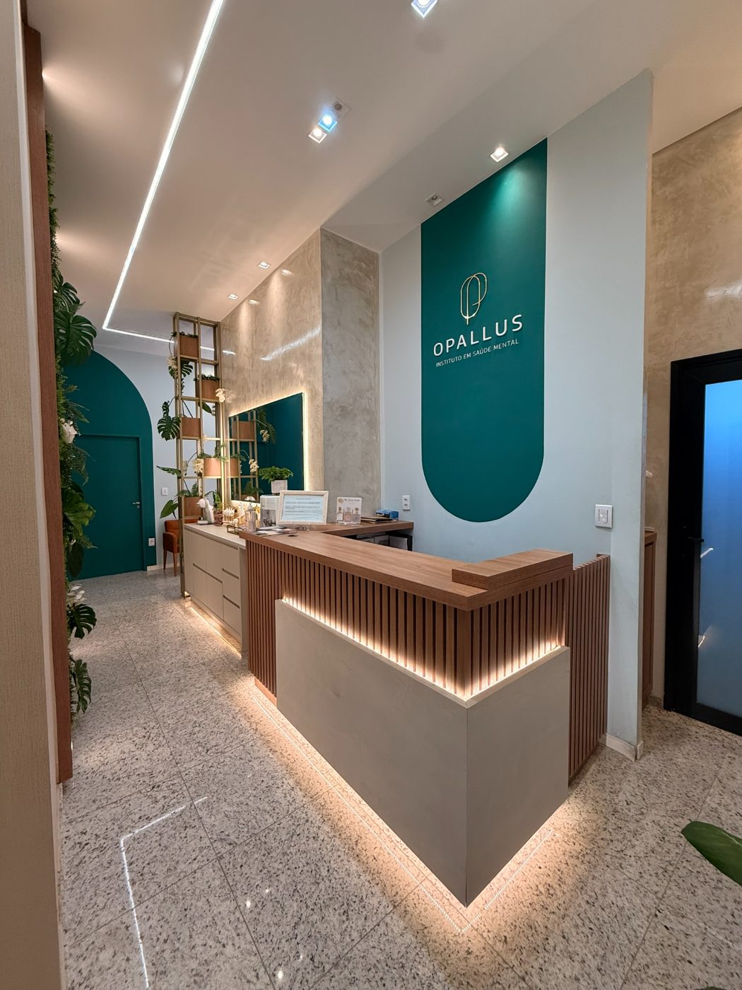 Recepção do consultório com detalhes em verde e dourado