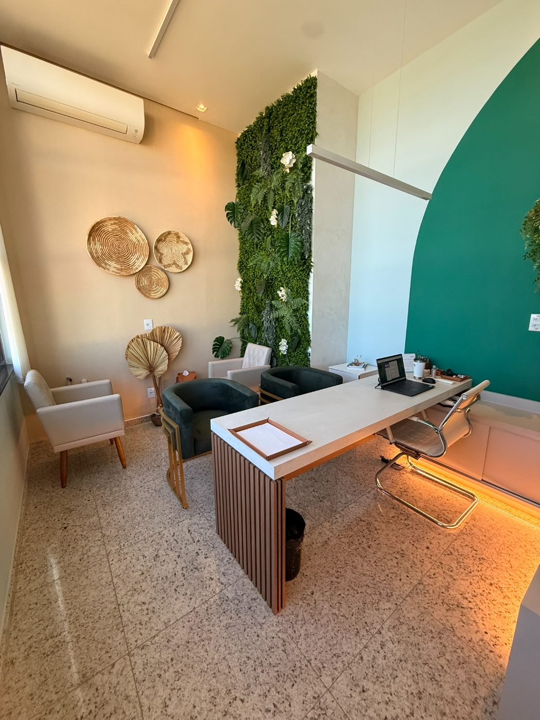 Sala de atendimento com parede verde em arco e jardim vertical